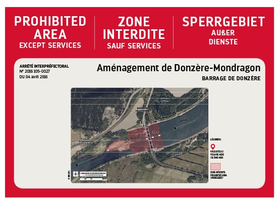 Panneau rouge, blanc et noir signalant une zone interdite autour de l’aménagement de Donzère-Mondragon. Une carte localise précisément le secteur concerné et les zones réglementées.